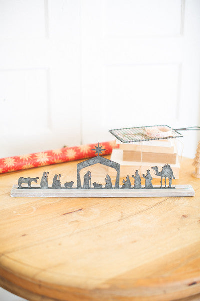 metal nativity on a wooden stand